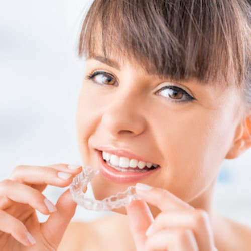 Woman about to put in an Invisalign clear aligner