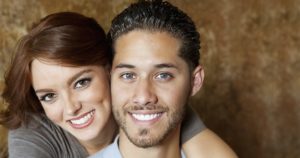 Man and woman smiling after a dental crown procedure at Love Your Smile