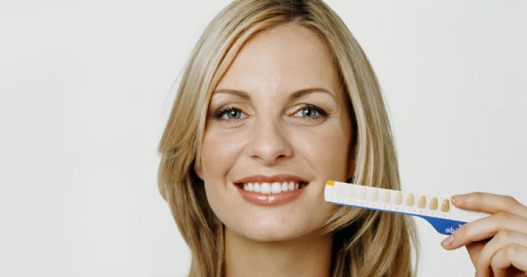 Woman smiling to check the whiteness shade of her teeth